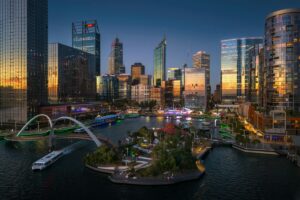 Perth City Skyline at Sunset. Western Australia’s Capital in Golden Hour Evening skyline of Perth, Western Australia, with city buildings lit up at sunset and reflections on the Swan River.